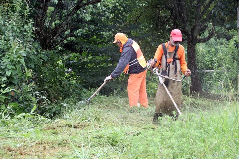 Equipe de dois trabalhadores realizando limpeza de chácara em Lins/SP